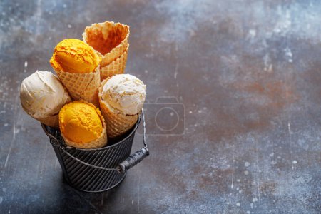 Téléchargez les photos : Saveurs variées de crème glacée dans de délicieux cônes de gaufres, un régal pour tous les papilles. Sur fond de pierre avec espace de copie - en image libre de droit