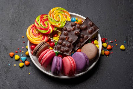 Photo for Various colorful candies, lollipops, and macaroons. Over stone background - Royalty Free Image