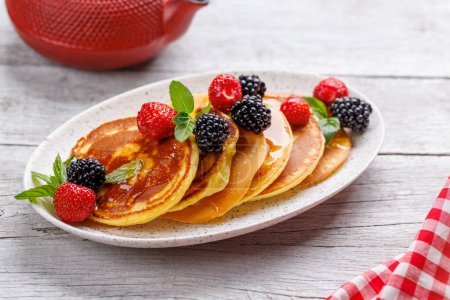 Photo for Tasty homemade pancakes with berries and honey syrup - Royalty Free Image