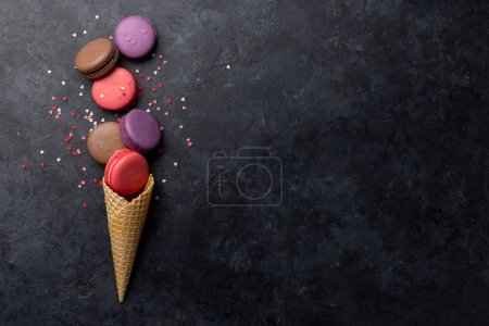 Téléchargez les photos : Divers macarons colorés. Poser des bonbons plats sur fond de pierre avec espace de copie - en image libre de droit