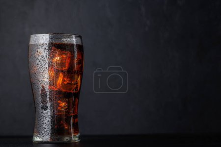 Téléchargez les photos : Cola avec glace en verre sur fond noir avec espace de copie - en image libre de droit
