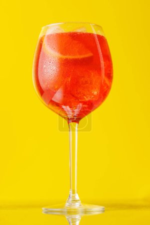Téléchargez les photos : Aperol Spritz cocktail avec tranche d'orange et glace sur jaune - en image libre de droit