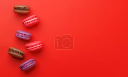 Foto de Varios macarrones coloridos. Piso sobre fondo rojo con espacio de copia - Imagen libre de derechos