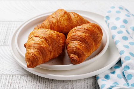 Photo for Fresh croissants on plate on wooden board - Royalty Free Image