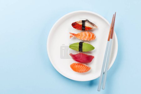 Foto de Varios platos de sushi en la mesa azul. Piso con espacio de copia - Imagen libre de derechos