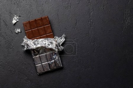 Sweet temptation: Chocolate bar on stone background with copy space