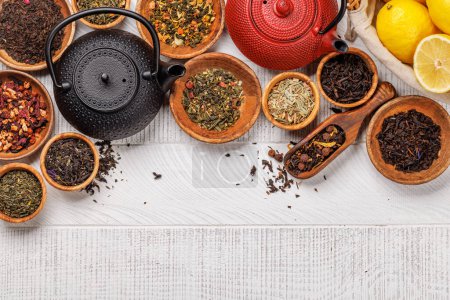 Téléchargez les photos : Une collection de différents thés nichés dans des bols en bois. Pose plate avec espace de copie - en image libre de droit