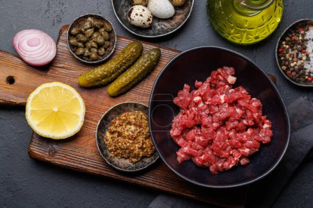 Photo for Cooking savory beef tartare with pickled gherkins and brown bread toasts. Flat lay - Royalty Free Image