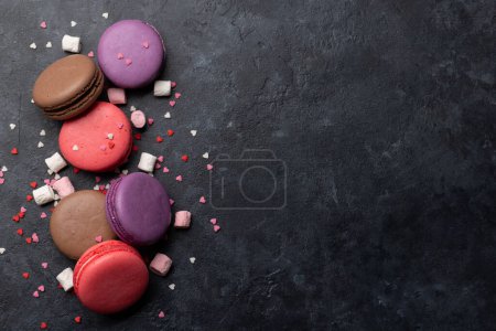 Téléchargez les photos : Divers macarons colorés. Poser des bonbons plats sur fond de pierre avec espace de copie - en image libre de droit