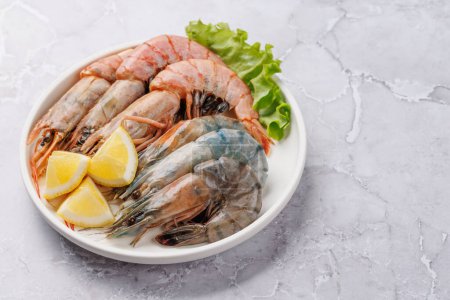 Téléchargez les photos : Crevettes crues sur assiette, prêtes à cuire. Avec espace de copie - en image libre de droit