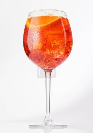 Aperol spritz cocktail with orange slice and ice on grey background