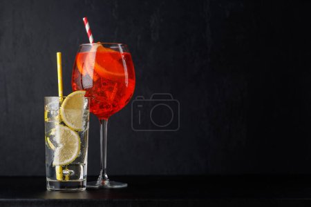 Aperol spritz and gin tonic cocktails on black with copy space