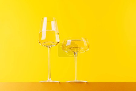 Champagner-Eleganz: Sektgläser vor leuchtendem gelben Hintergrund. Mit Kopierraum