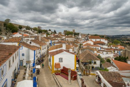 Photo for Narrow streets inside of the obidos castle in Portugal. Top view of the medieval fortified Obidos town, Portugal. Beautiful historic Portuguese buildings with tiled roofs - Royalty Free Image