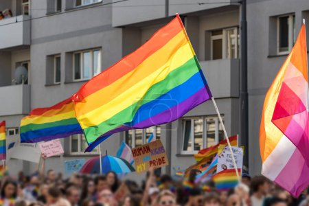 Foto de Las banderas del arco iris se centran en un desfile del orgullo gay en Europa. La gente está borrosa. - Imagen libre de derechos