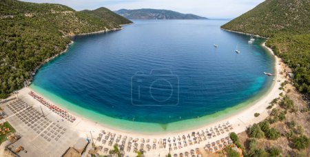 Panorama of Antisamos beach with crystal clear azure water on Kefalonia island, Greece. Aerial view of the paradise beach with sunbeds on Kefalonia island, Ionian island, Greece.