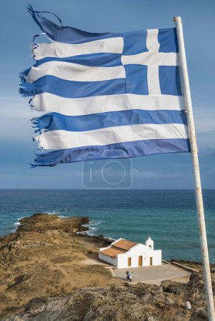 Foto de Bandera nacional de Grecia primer plano con una pequeña capilla de Agios Nikolas en un fondo en la isla de Zante, mar Jónico, Grecia. Paisaje de la costa de la isla de Zakynthos - Imagen libre de derechos