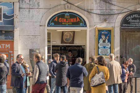 Téléchargez les photos : Lisbonne, Portugal - 30 mars 2022 : Les clients buvant de la liqueur de cerise portugaise typique Ginjinha dans un bar ouvert historique populaire près de la place Rossio à Lisbonne. - en image libre de droit