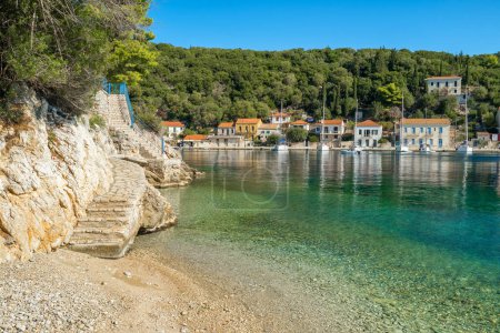 Photo for Small beach in picturesque Kioni fishing village on the Ithaca island, Kefalonia, Ionian sea, Greece. Stairs by the sea in Kioni village on Ithaki. Still shot of the idyllic Greek island scenery - Royalty Free Image