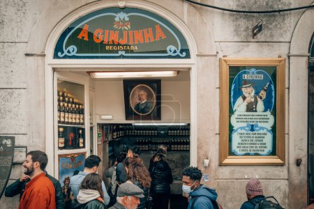 Téléchargez les photos : Lisbonne, Portugal - 25 mars 2022 : Les clients buvant de la liqueur de cerise portugaise typique Ginjinha dans un bar ouvert historique populaire près de la place Rossio à Lisbonne. - en image libre de droit