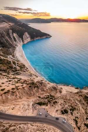 Foto de Puesta de sol sobre la famosa playa de Myrtos en la isla de Cefalonia, mar Jónico, Grecia. Vista aérea de la popular playa de Myrtos. - Imagen libre de derechos