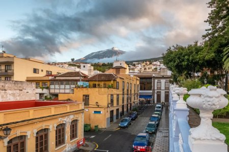 Photo for View of El Teide volcano from Icod de los Vinos town on Tenerife during sunset. The snow-capped Teide mountain is visible from Icod downtown, Canary Islands, Spain. - Royalty Free Image