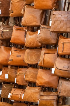 Photo for Stylish ladies leather bags showcased on an outdoor stall. Handmade leather bags background. Fashion and leather products concept - Royalty Free Image