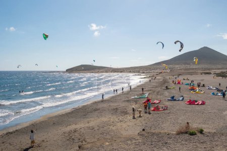Photo for Tenerife, Spain - January 11, 2023: El Medano surfing beach in south Tenerife, Canary Islands, Spain. Many kitesurfers with kites catching wind on the popular surfers beach in Tenerife - Royalty Free Image