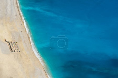 Photo for Beautiful Myrtos beach on a sunny summer day on Kefalonia island, Ionian sea, Greece. Idyllic white sandy beach on the shores of a beautiful turquoise sea. Empty beach with sunbed umbrellas - Royalty Free Image