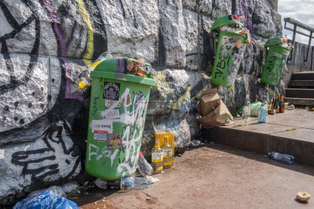 Photo for Prague, Czech Republic - June 12, 2022: Green city garbage bins full of trash. Rubbish is scattered around the trash can on the street. Waste recycling concept in the city. Urban problems. - Royalty Free Image