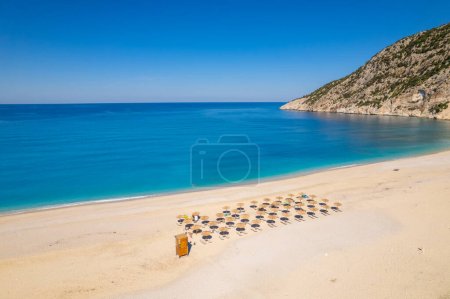Photo for Beautiful Myrtos beach on a sunny summer day on Kefalonia island, Ionian sea, Greece. Idyllic white sandy beach on the shores of a beautiful turquoise sea. Empty beach with sunbed umbrellas - Royalty Free Image