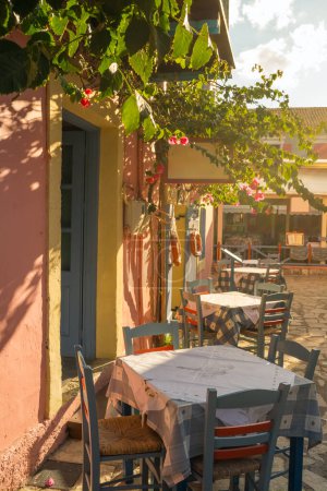 Photo for Cozy outdoor cafe in Fiskardo fishing village on Kefalonia island, Greece. Greek travel destination - Royalty Free Image