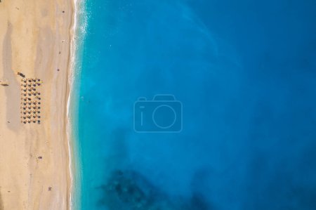 Beautiful Myrtos beach on a sunny summer day on Kefalonia island, Ionian sea, Greece. Idyllic white sandy beach on the shores of a beautiful turquoise sea. Empty beach with sunbed umbrellas