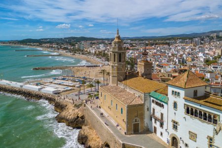 Vista aérea de la ciudad costera de Sitges y la iglesia de San Bartolomé y Santa Tecla en un día soleado en Sitges, Cataluña, España