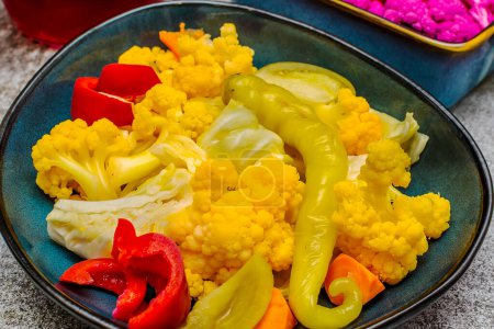 Photo for Homemade pickle with yellow and purple cauliflower in a plate on a gray background - Royalty Free Image