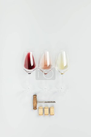 Flache Lage von Rot-, Rosen- und Weißwein in Gläsern auf weißem Hintergrund. Weinbar, Weingut, Degustationskonzept. Minimalistische Trendfotografie