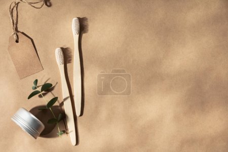Téléchargez les photos : Deux brosses à dents naturelles en bois sur fond beige naturel avec des feuilles ombragées, à plat, vue sur le dessus. Concept de zéro déchet et soins dentaires naturels. Espace de copie - en image libre de droit