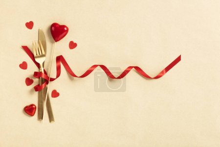 Photo for Fork and knife tied with a red ribbon. Romantic dinner. Valentines Day. Top view, flat lay, copy space - Royalty Free Image