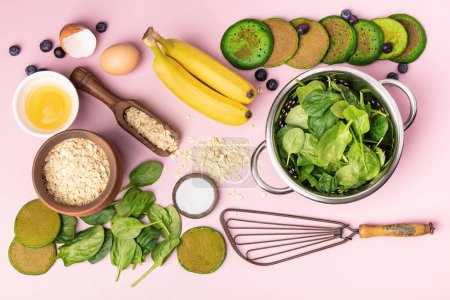 Photo for Spinach pancakes and ingredients, flat lay on pink background - Royalty Free Image