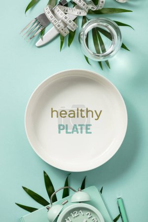 Photo for Composition with cutlery, plate, measuring tape, blank paper notebook and alarm clock on color background. Diet healthy eating detox concept, motivating quote - Royalty Free Image