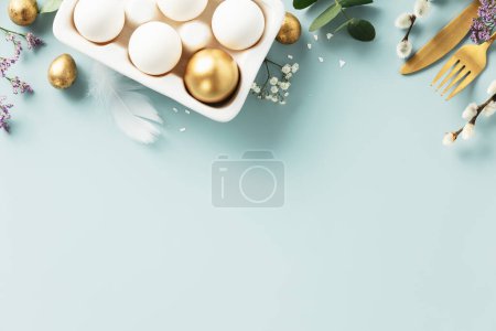 Foto de Easter table decorations. Happy Easter concept with golden table setting, easter eggs, feathers and spring flowers. Easter background with copy space. Flat lay - Imagen libre de derechos