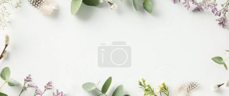 Foto de Spring flower frame on blue background copy space flat lay mock up. Concept of greeting - Imagen libre de derechos