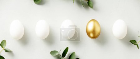 Téléchargez les photos : White chicken eggs with one golden egg flat lay top view banner. standing out from the crowd - en image libre de droit