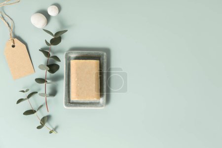 Foto de Productos naturales para el cuidado de la piel: jabón hecho a mano y hojas de eucalipto sobre fondo azul. Residuos cero, baño ecológico y accesorios de spa planas - Imagen libre de derechos