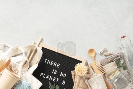 Foto de There is no planet b letter board and Plastic free set with cotton bags, glass jars, green leaves and recycled tableware top view. Zero waste, eco friendly concept. Flat lay. - Imagen libre de derechos