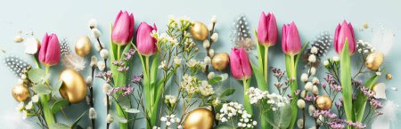 Foto de Composición de Pascua con hermosas flores de primavera y huevos de Pascua dorados sobre fondo azul pancarta plana poner vista superior - Imagen libre de derechos