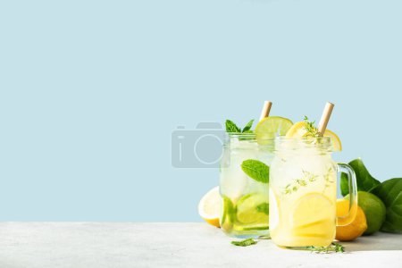Photo for Lemonade and mojito on blue sky background. Refreshing homemade cocktails summer drinks, selective focus. Sunny day shadows - Royalty Free Image