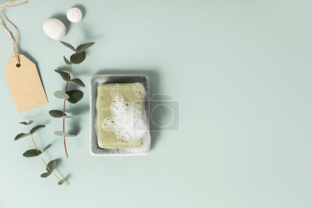Téléchargez les photos : Produits naturels de soin de la peau savon fait main et feuilles d'eucalyptus sur fond bleu. Zéro déchet, salle de bain écologique et accessoires spa flat lay - en image libre de droit
