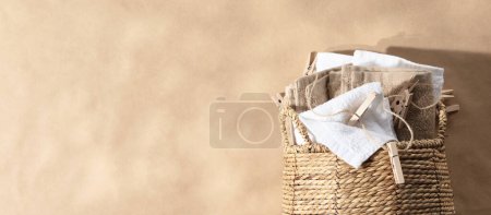 Photo for Eco-friendly laundry and housekeeping concept. Straw wicker basket with natural cotton fabric and wooden Clothespins. Natural eco materials, storage basket banner copy space - Royalty Free Image