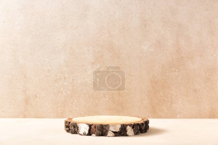 Téléchargez les photos : Empty round wooden podium for product presentation, pink gypsophila flowers on beige background. Natural materials background for cosmetic advertising with cylinder shape showcase. Mockup concept. - en image libre de droit